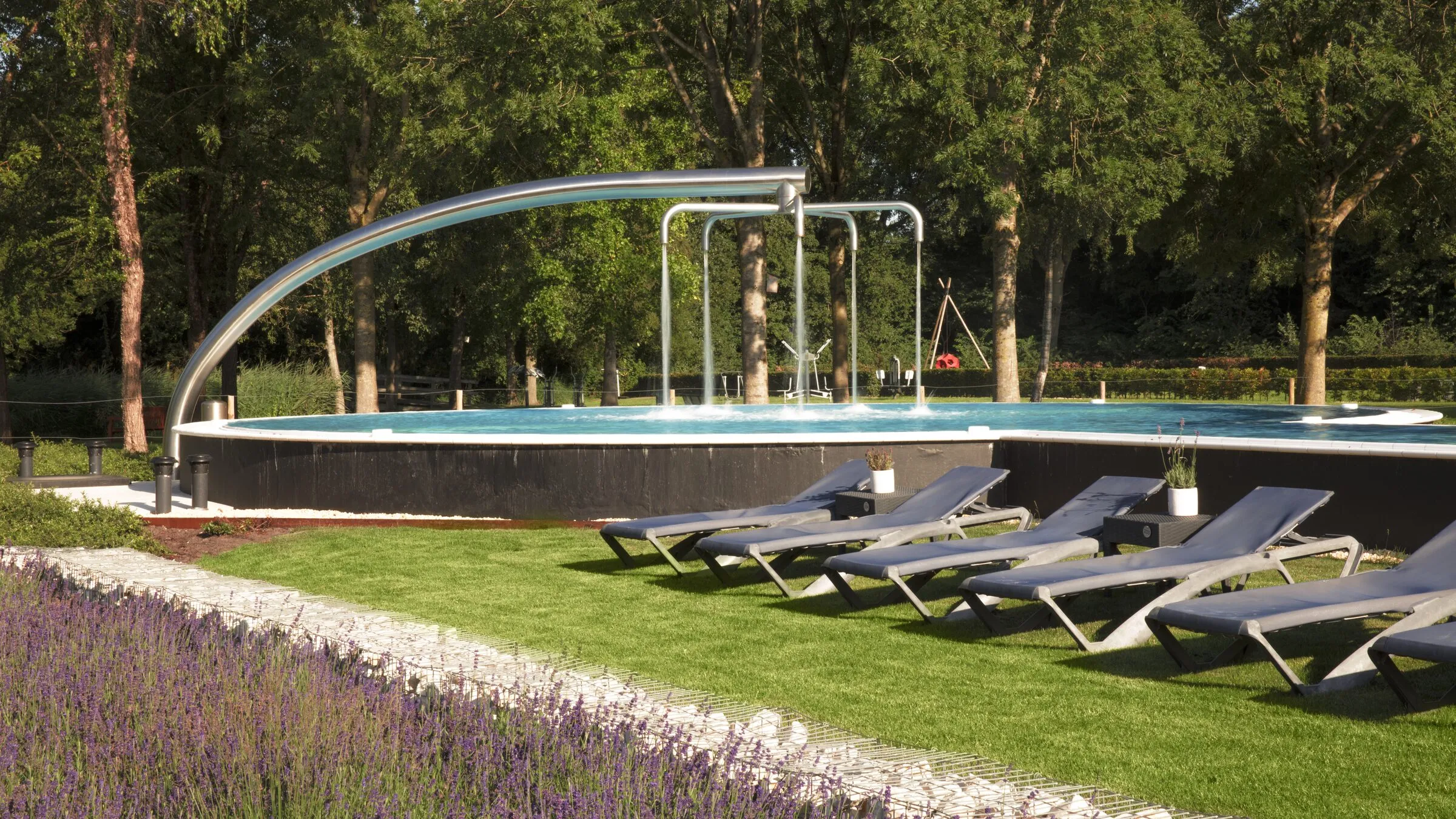 Een buitenmineraalbad van Thermen Bad Nieuweschans met ligweide en lavendel