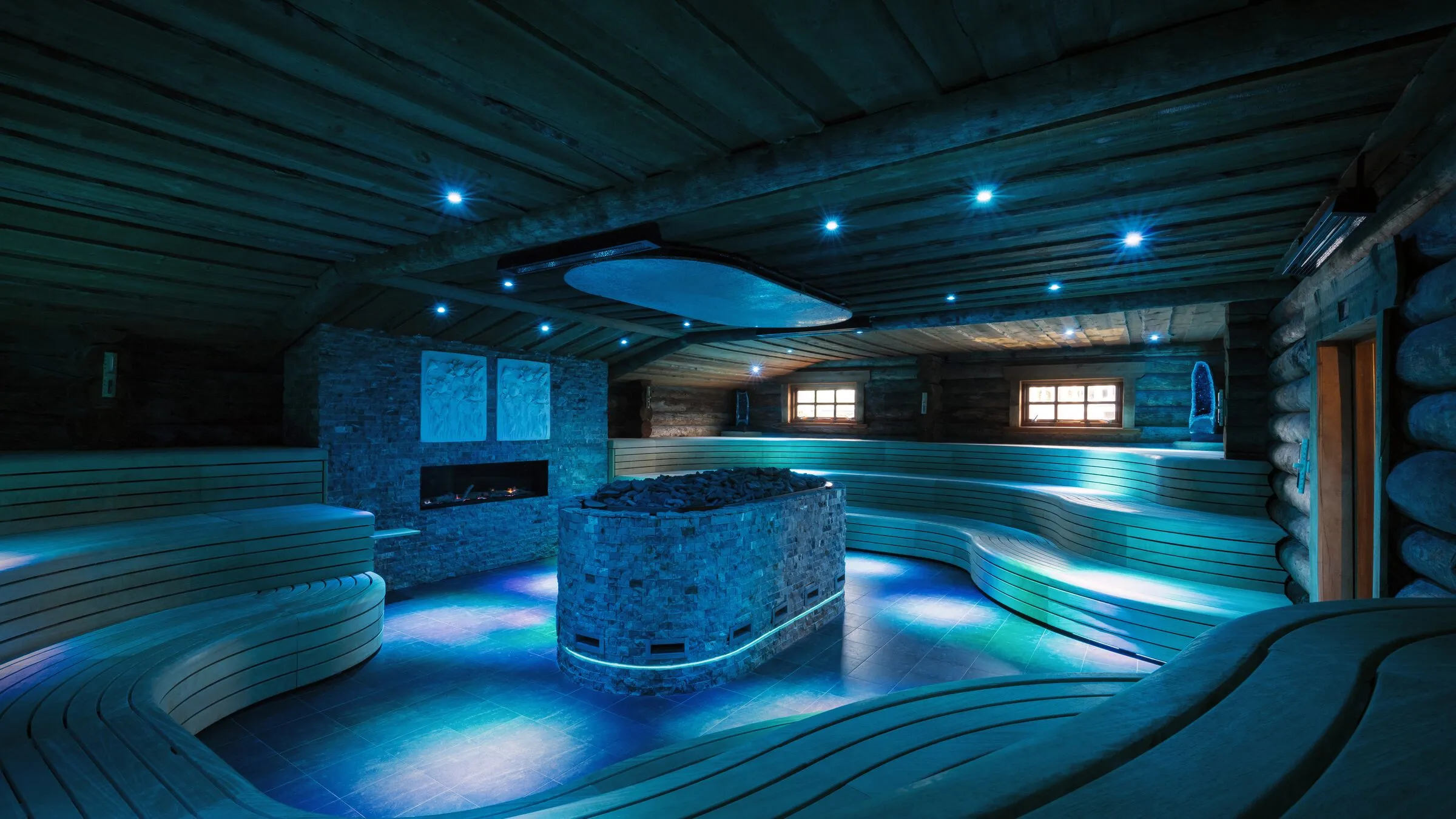 De Kelo Aufguss sauna van Thermen Bussloo, gebouwd van boomstammen, met blauw licht rond de kachel