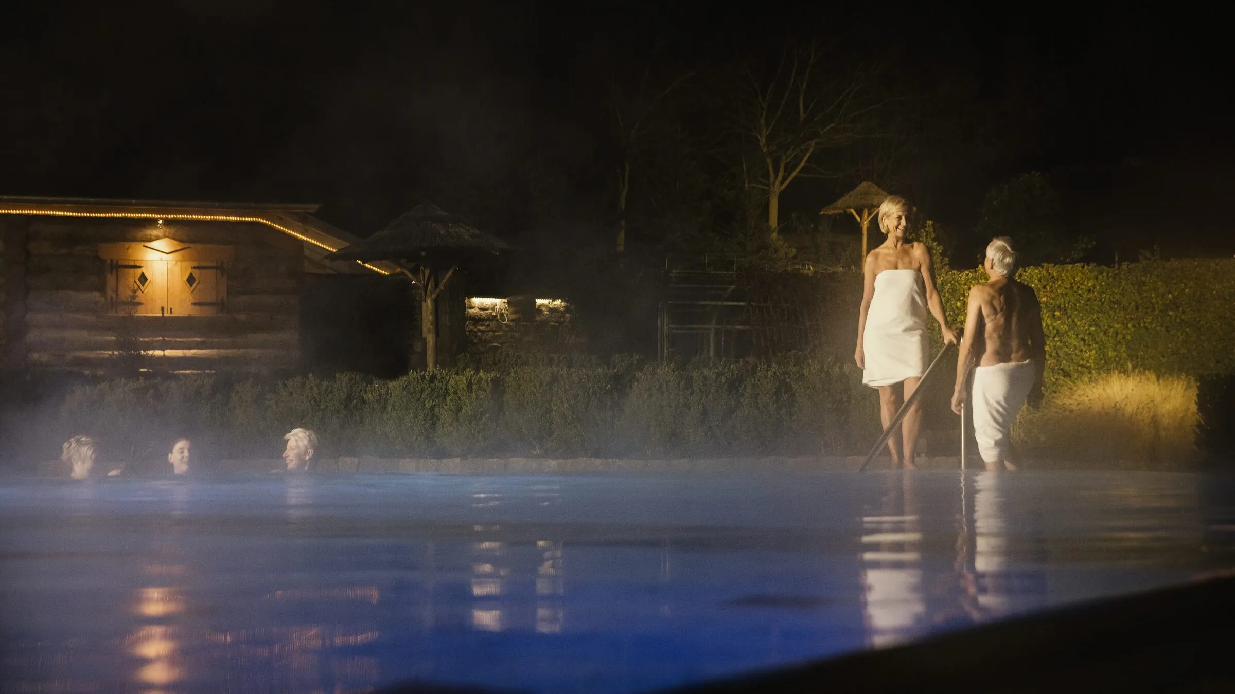 Het buitenzwembad van Thermen Bussloo in de avond, met stoom boven het water