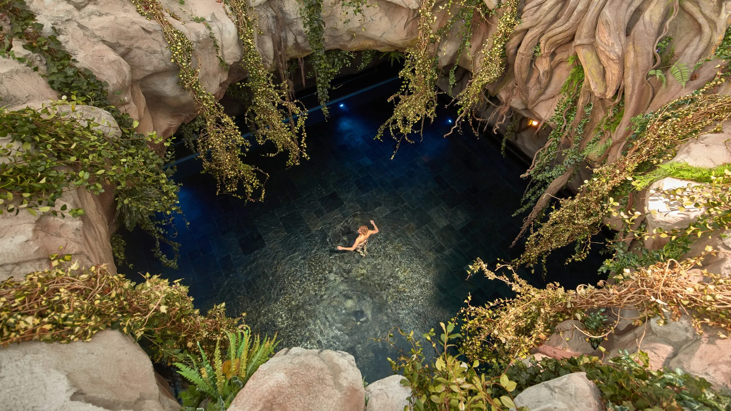Het Cenote zoutwaterbad van Thermen Bussloo van boven, tussen rotsen en groen
