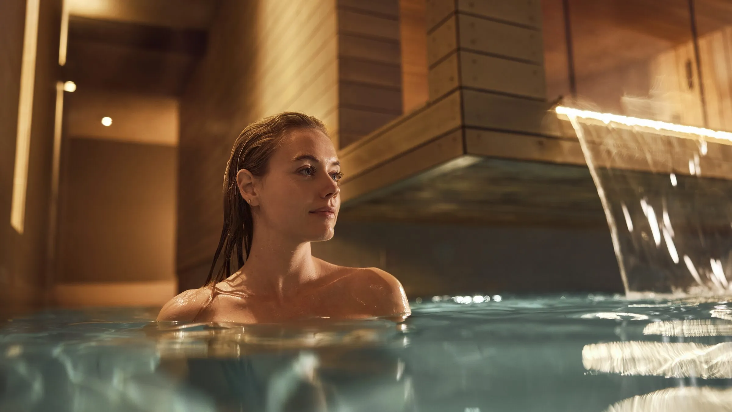 Het binnenzwembad van Thermen Maarssen met een waterval uit de houten wand