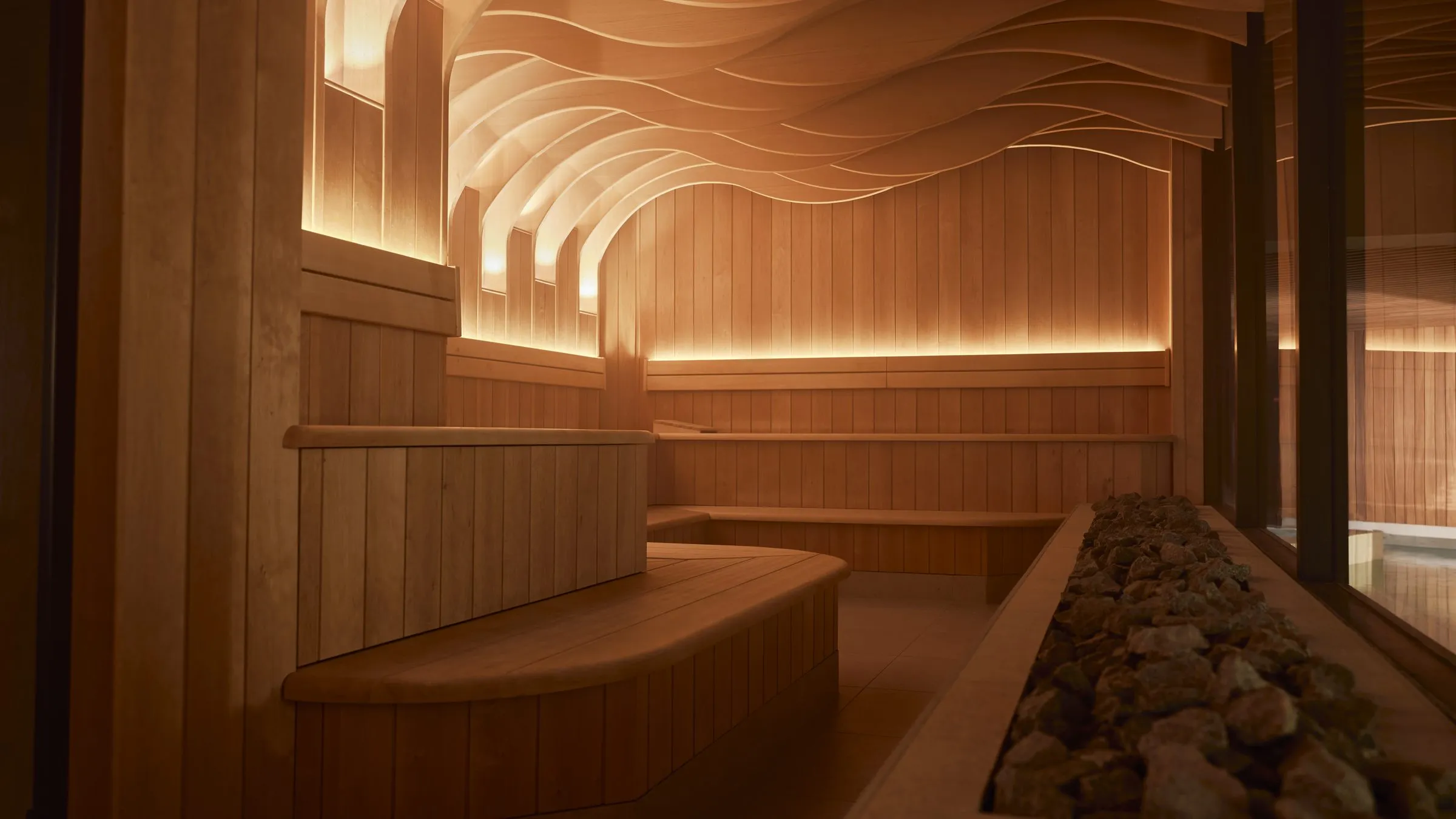 Saunaruimte van Thermen Maastricht met houten banken en een golvend, verlicht plafond
