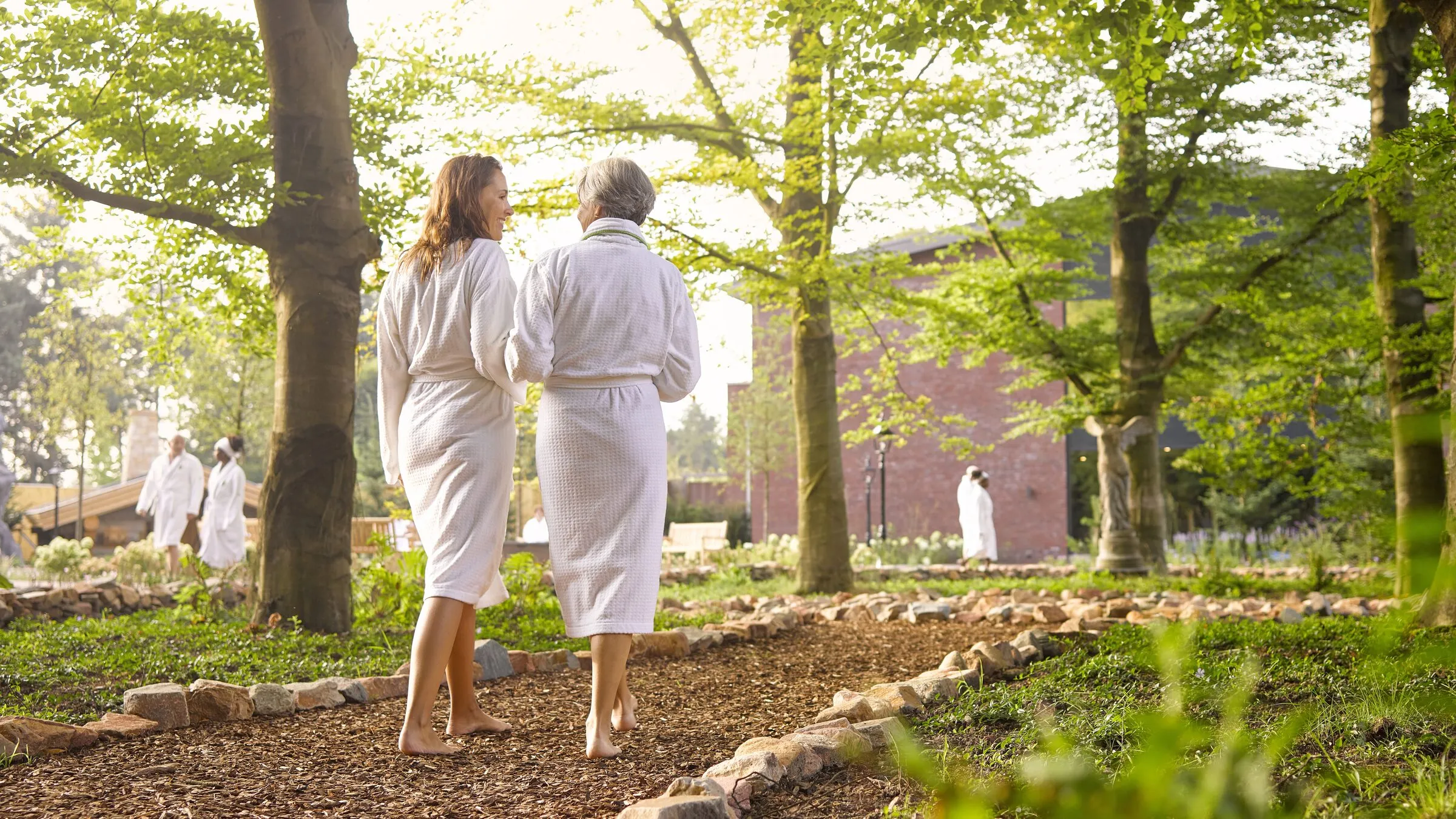 Het labyrint in de tuin van Thermen Soesterberg, met gasten in badjas tussen de beuken