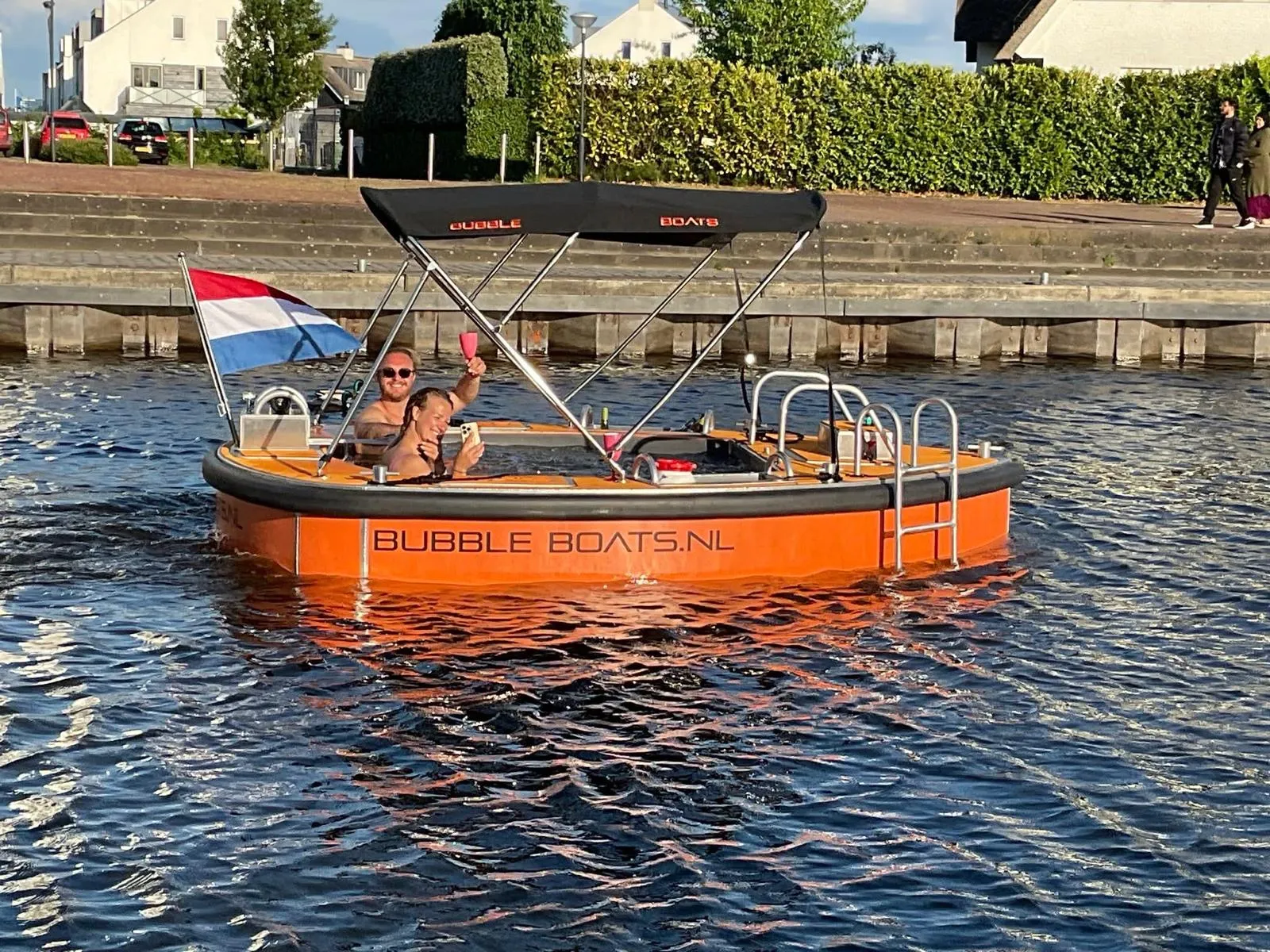 Oranje varende jacuzzi van Bubble Boats vaart over het water bij Loosdrecht